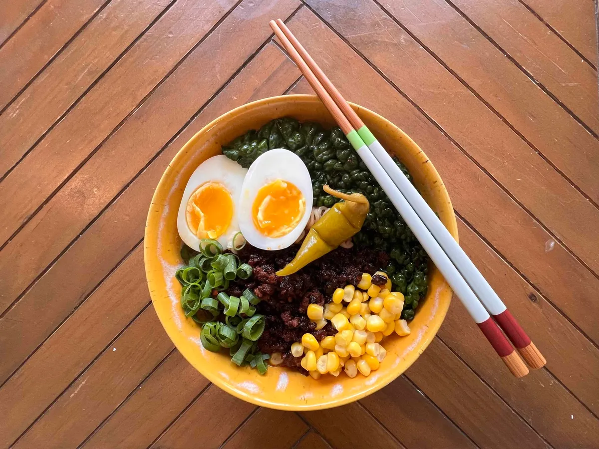 A bowl of tonkotsu ramen with chashu pork, soft-boiled egg, and green onions